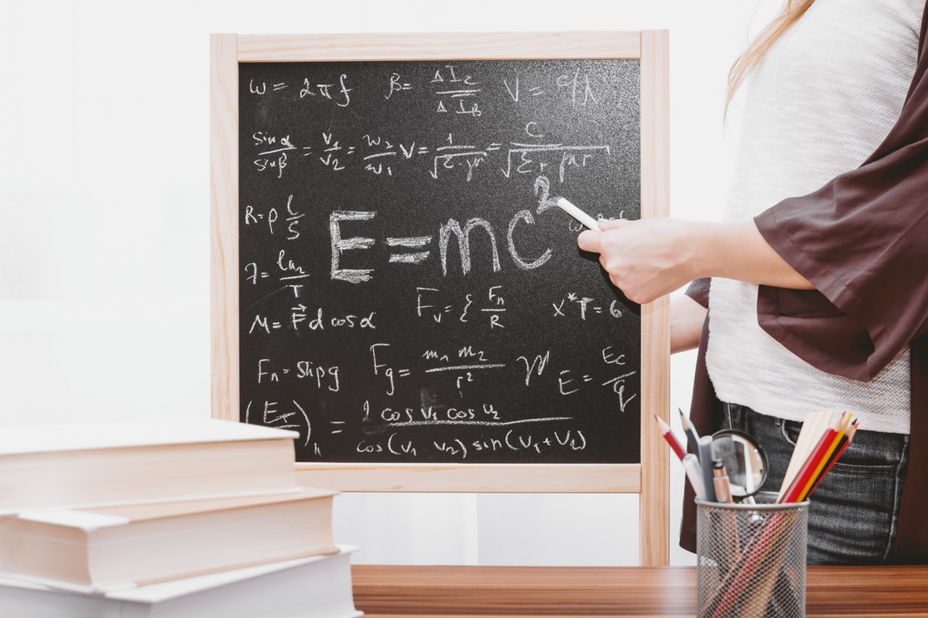 Woman pointing to equation on chalkboard